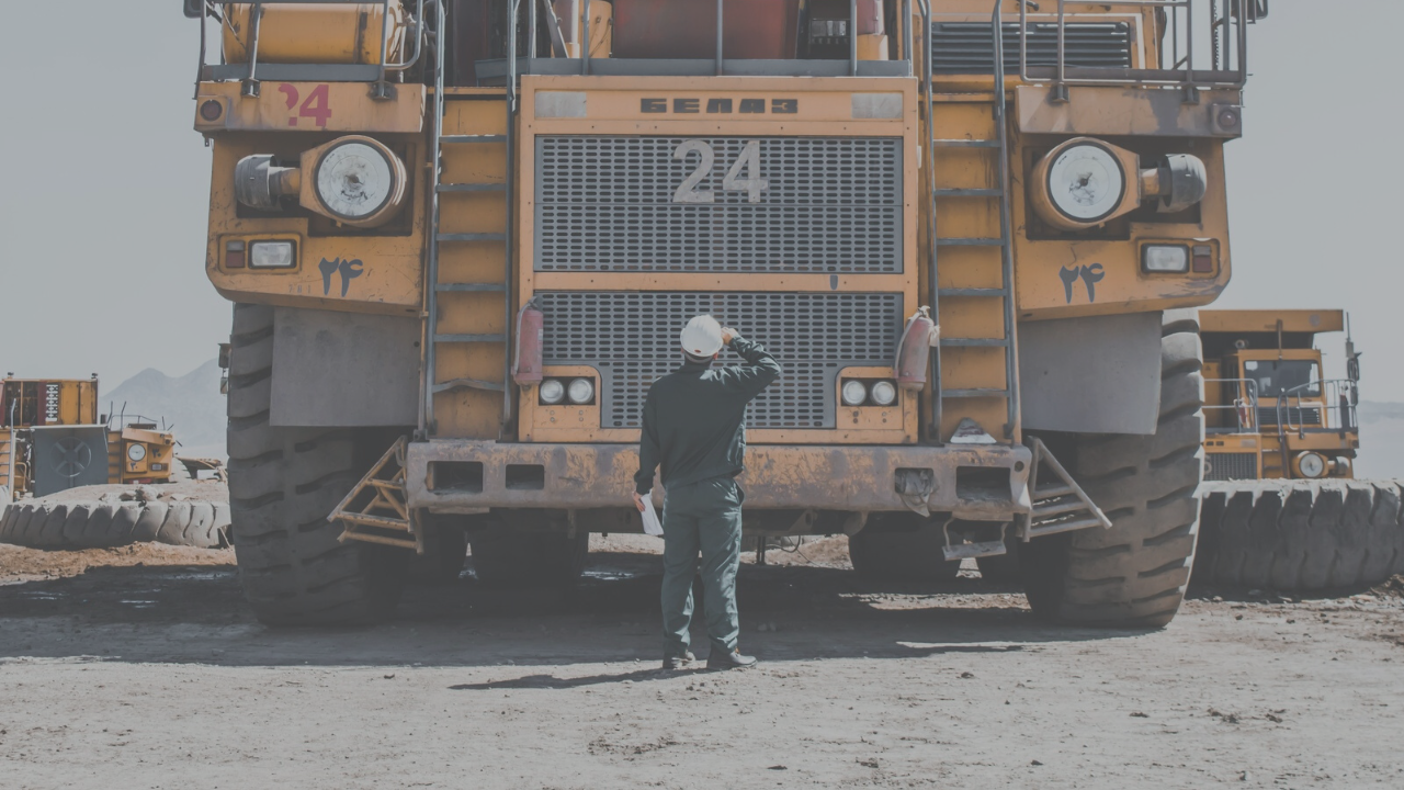 Mining employee looking at vehicle.